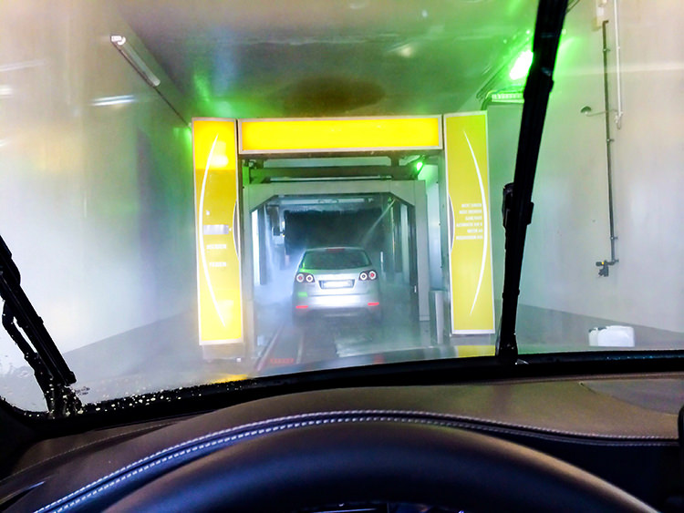 Blick aus Windschutzscheibe während der Fahrt durch eine Waschanlage