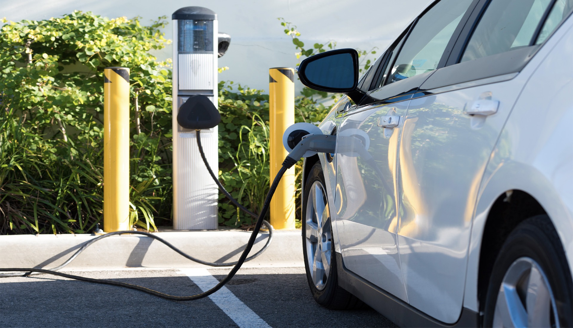 Weißes Auto an E-Ladesäule