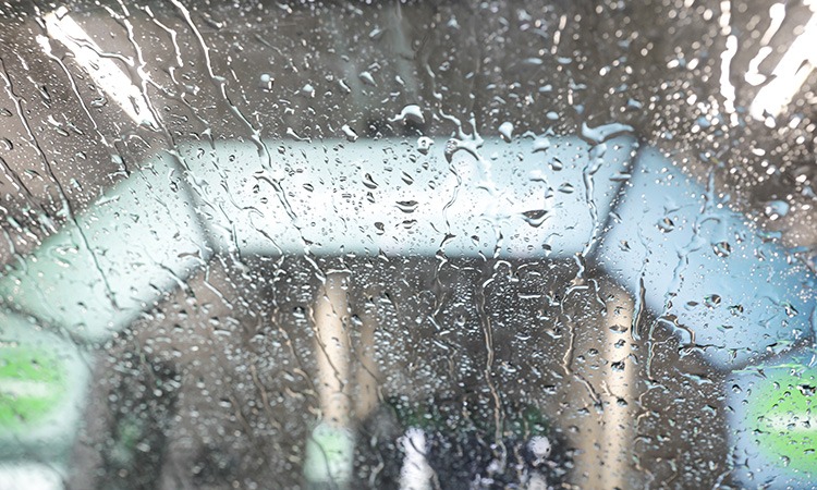 Regentropfen auf Windschutzscheibe mit Blick auf Autowaschstraße