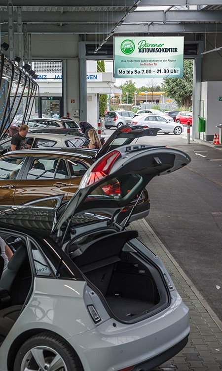 Ausfahrt der Outdoor-Saugerplätze im Dürener Autowaschcenter mit Monitor Informationen zu den Öffnungszeiten